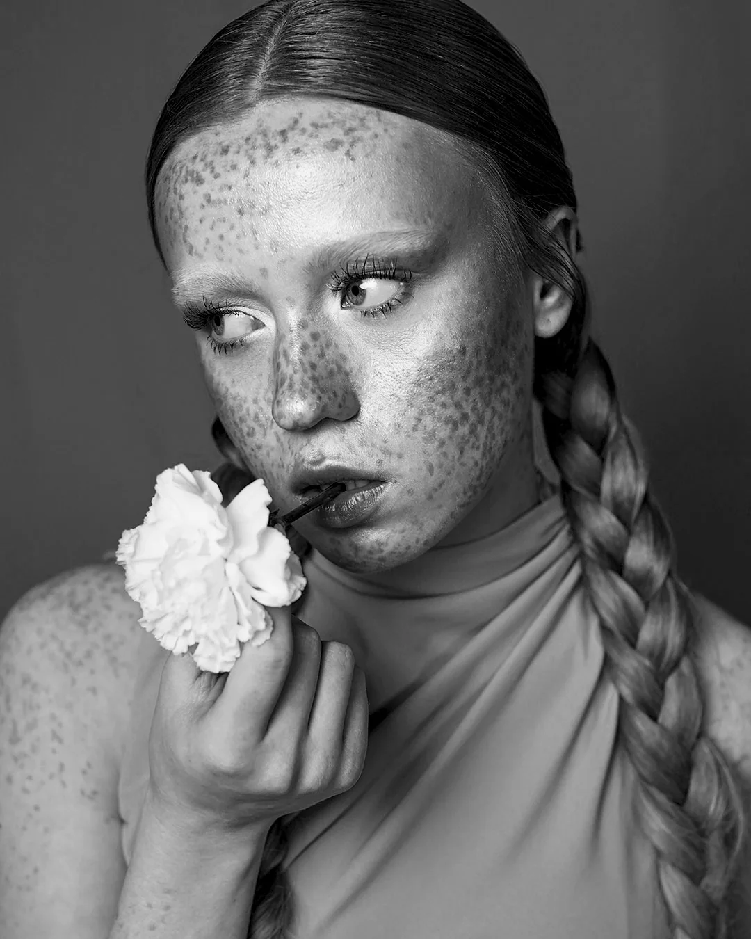 Black and white portrait with a flower at the lips