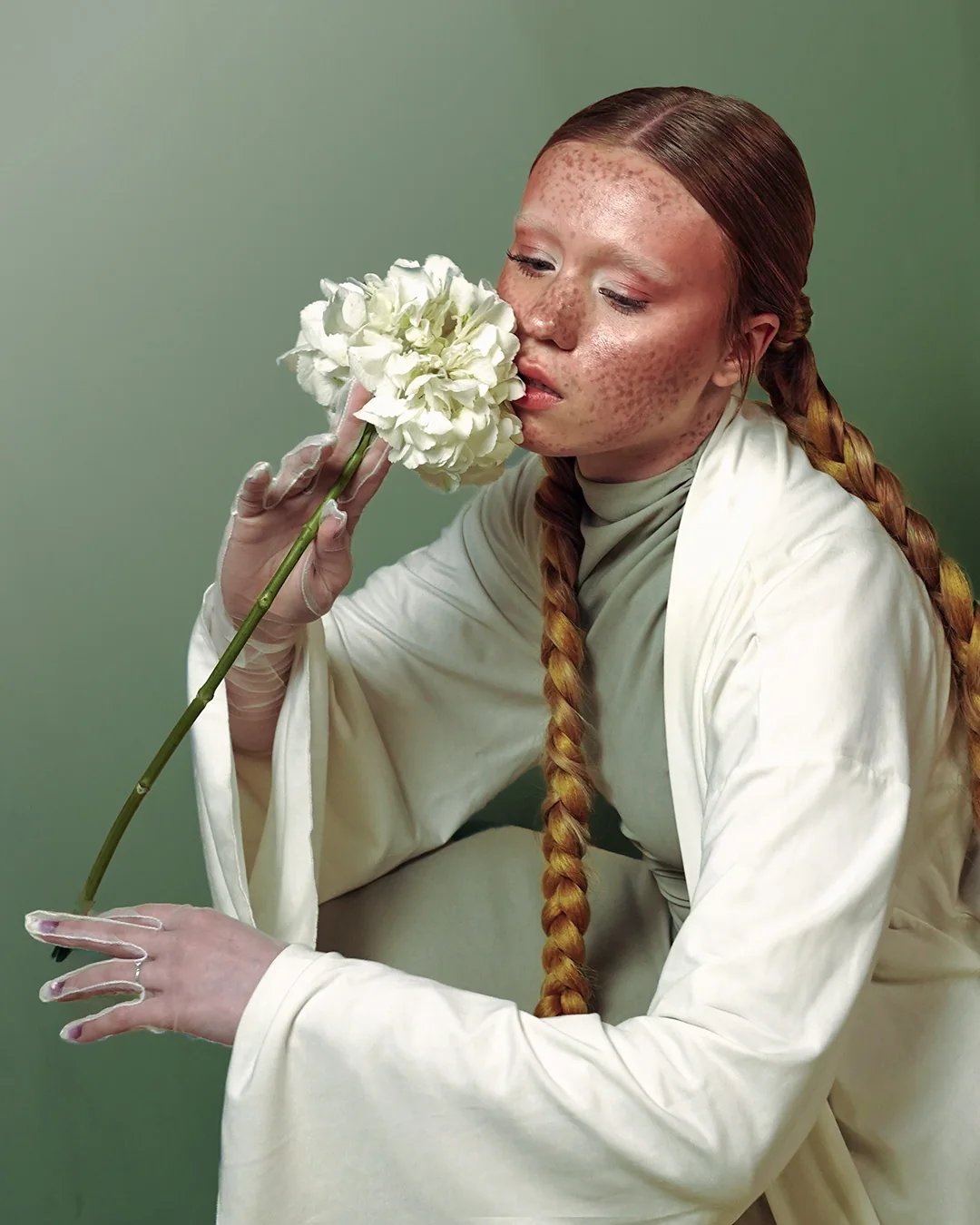 Portrait kissing a white flower, long braid