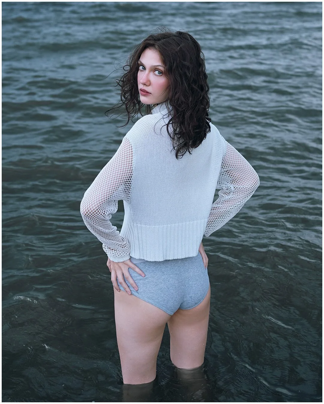Figure standing in the sea, back to camera